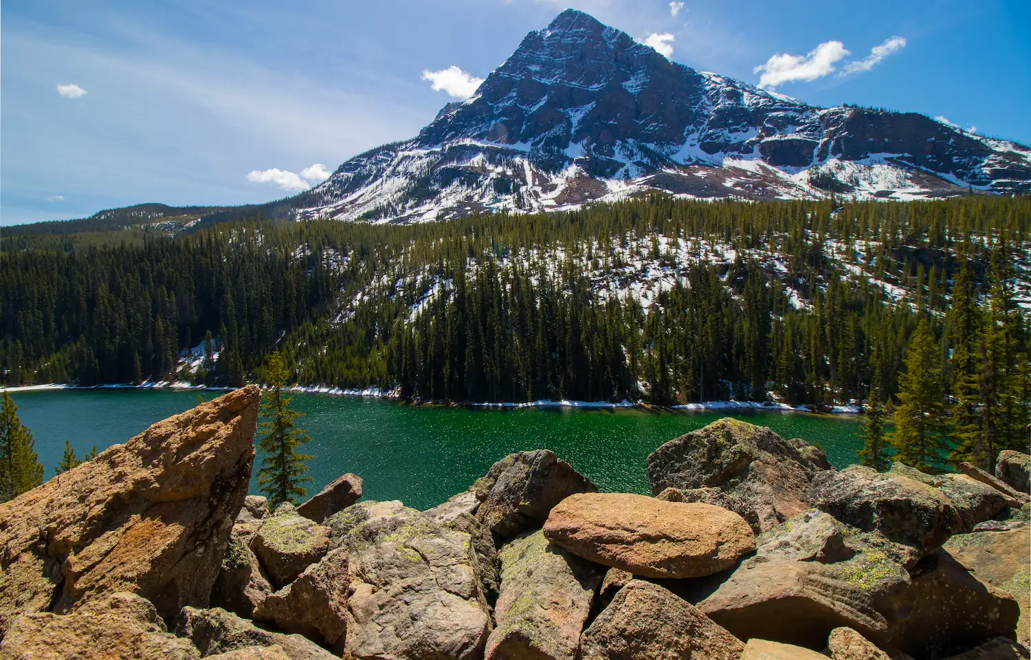Emerald green alpine lake with mountain backdrop